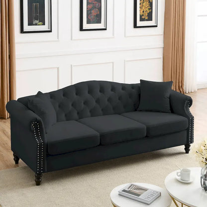 Made of black velvet, suitable for the living room. Three-seater sofa with tufted fabric, rolled-edge armrests, and studded details.