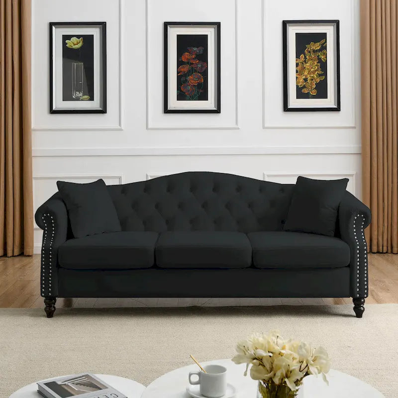 Made of black velvet, suitable for the living room. Three-seater sofa with tufted fabric, rolled-edge armrests, and studded details.