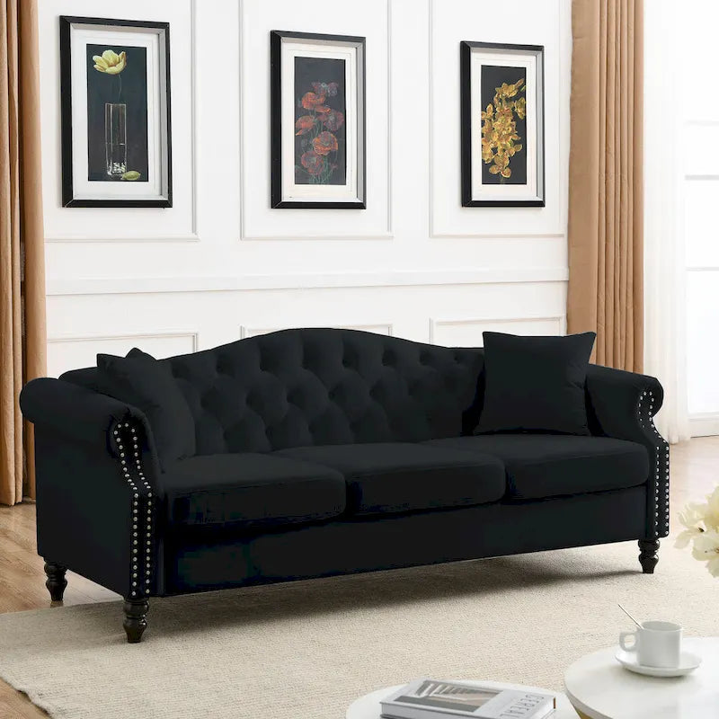 Made of black velvet, suitable for the living room. Three-seater sofa with tufted fabric, rolled-edge armrests, and studded details.